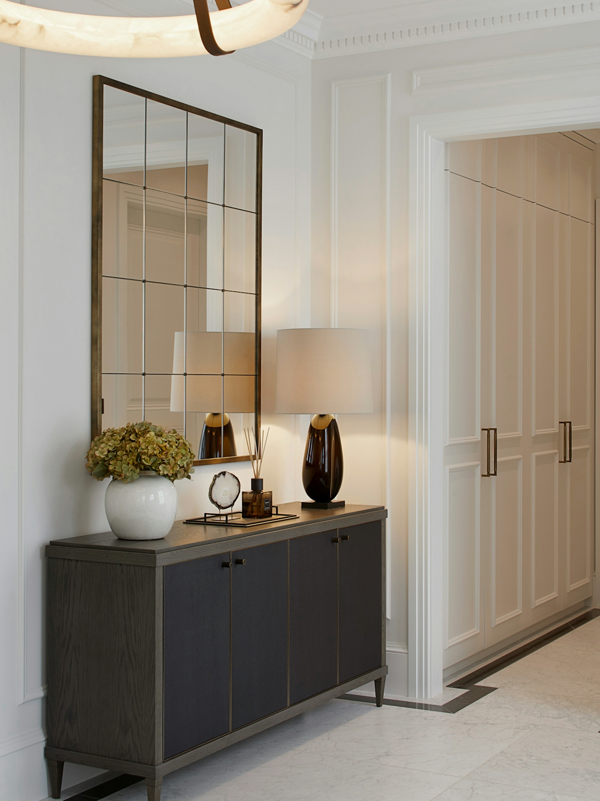 Entanceway with antique mirror, dark wood cabinet, alabaster light fixture
